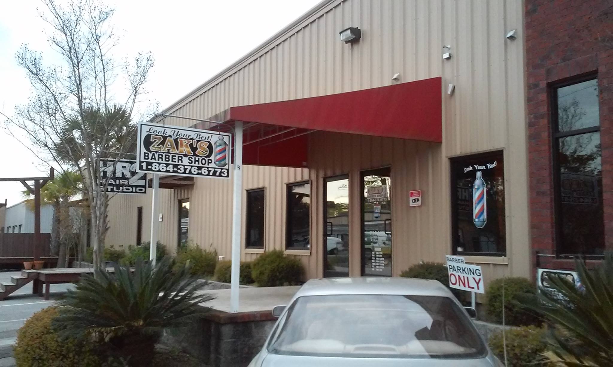 The shopfront on Socastee Blvd with the barber pole sign and red awning
